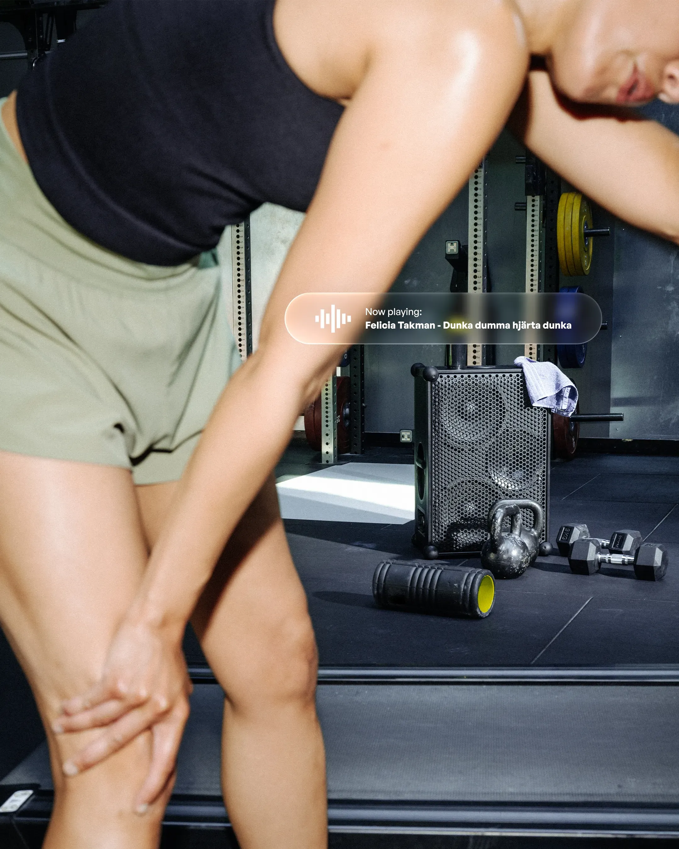 A woman in a gym next to a notification. Now playing: Felicia Takman - Dunka dumma hjärta dunka.