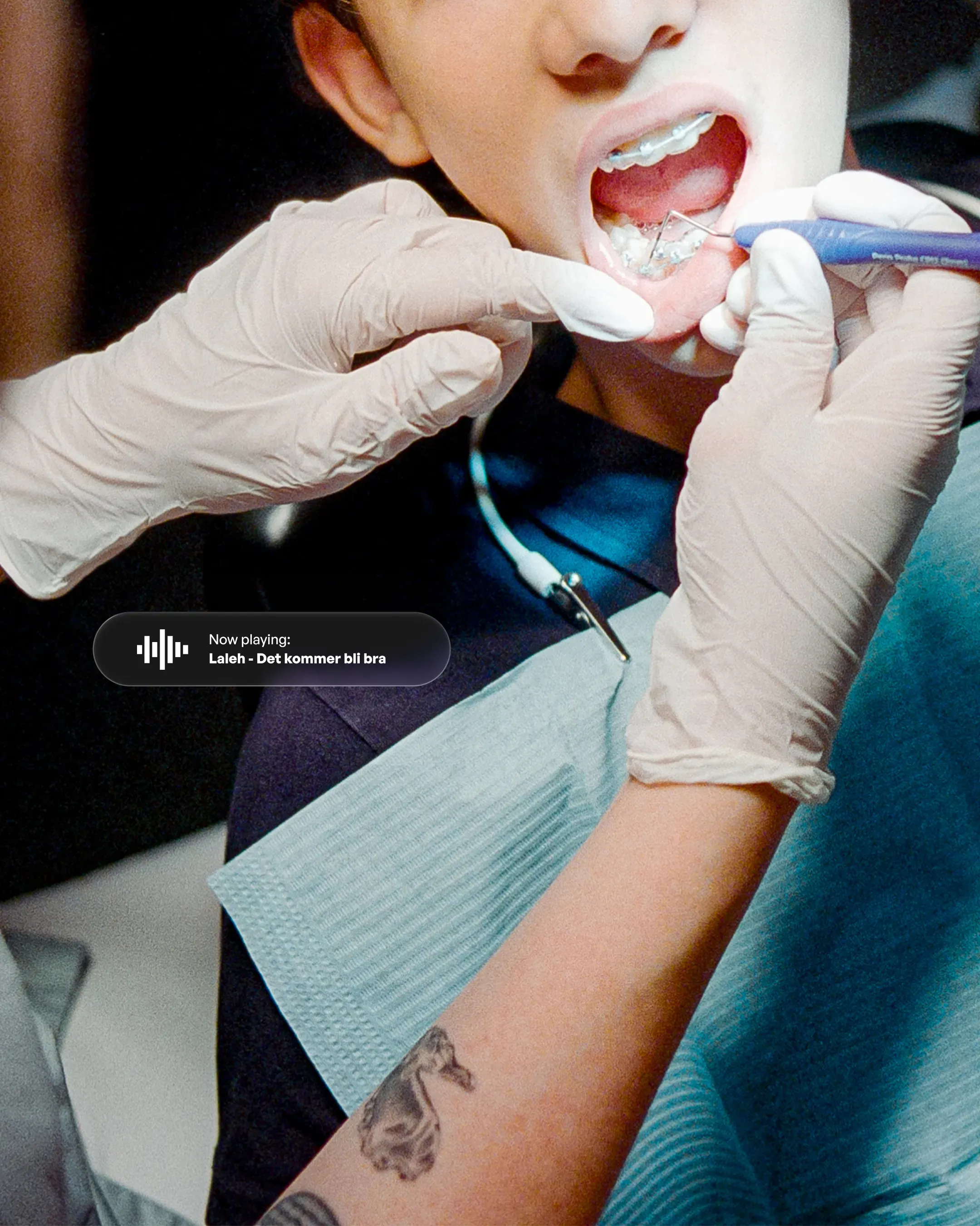 Close-up of a man in a dentist chair next to a notification. Now playing: Laleh - Det kommer bli bra.